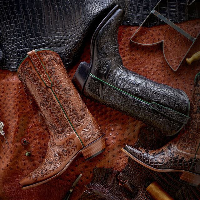 Custom black and brown tooled boots on leather hide.